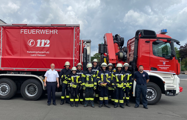 Feuerwehrmänner und -frau vor Feuerwehr-LKW