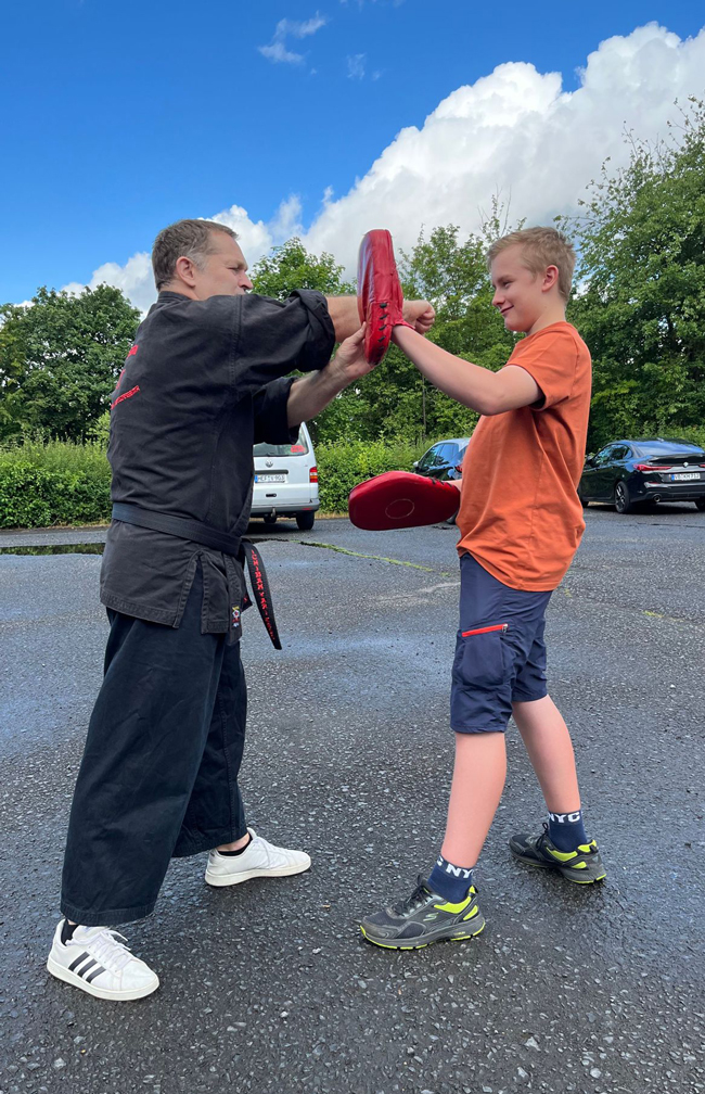 Ein Schüler und Herr Martin trainieren mit Handpratzen 