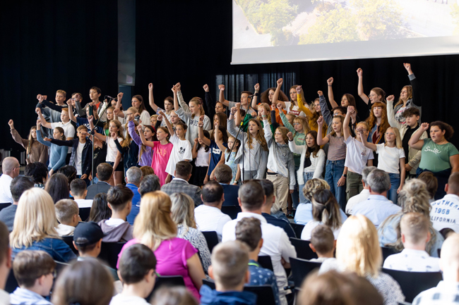 Chorschüler reißen Arme in die Höhe