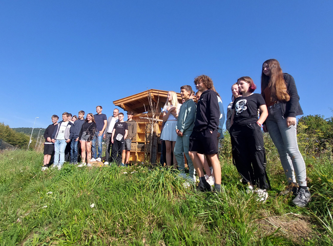 Schüler und Erwachsene vor dem Insektenhotel