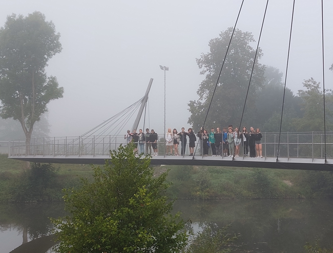 Schülergruppe auf einer Brücke im Nebel