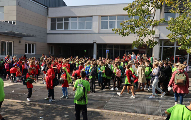 Blick auf den Schulhof mit zahlreichen Schülern in bunten T-Shirts