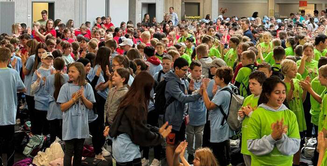 Halle voll mit hunderten Schülern in bunten T-Shirts