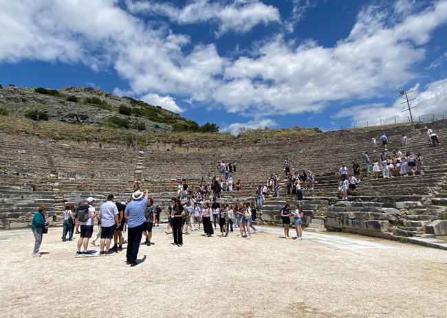Schüler erklimmen die Stufen in einem halb zerfallenen Amphitheater
