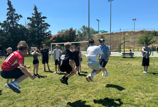 Schüler beim Seilspringen auf einem Sportplatz