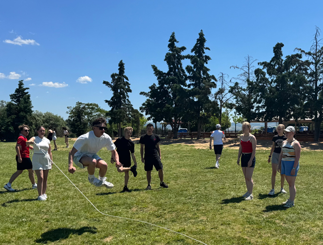Schüler beim Seilspringen auf einem Sportplatz