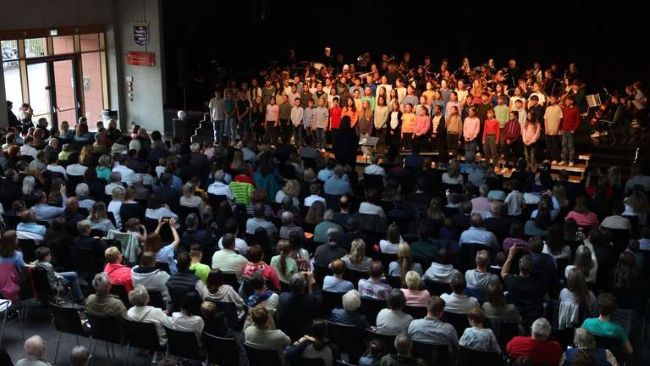 Publikum vor Chor und Orchester auf der Bühne
