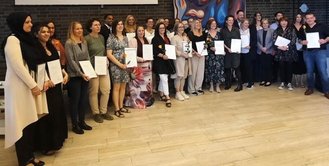 Gruppe von Personen mit Urkunden in der Hand