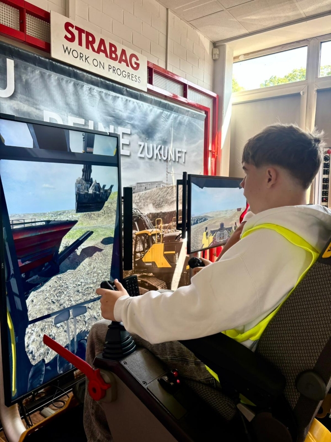 Schüler sitzt in einem Baggersimulator