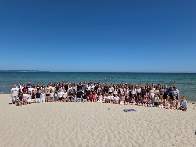 große Gruppe Schüler mit Lehrern am Strand