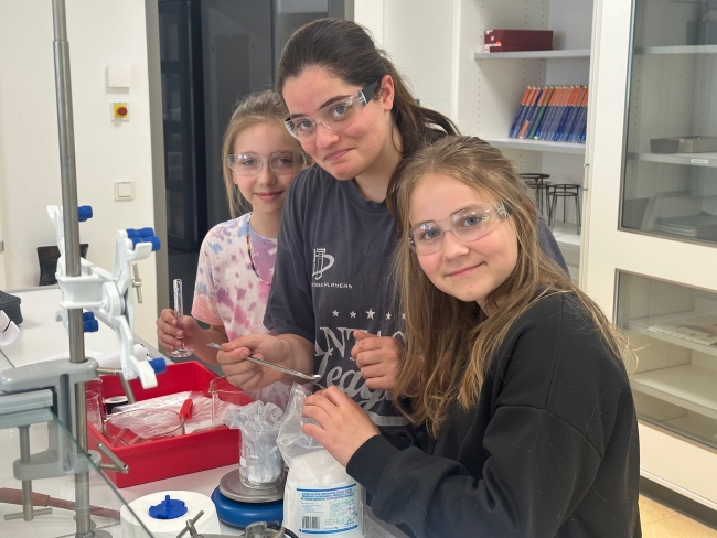 Drei Mädchen experimentieren in einem Chemieraum