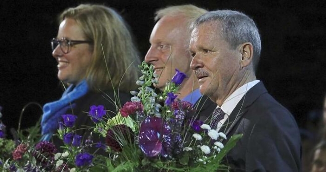 drei Personen in Nahaufnahme mit Blumensträußen in den Händen