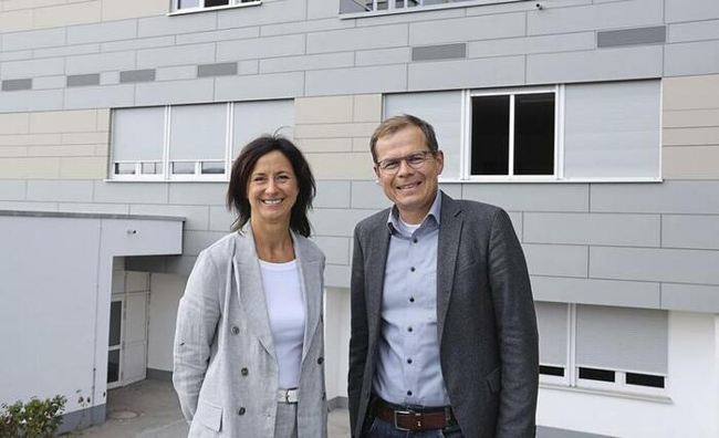 Mann und Frau vor Schulgebäude