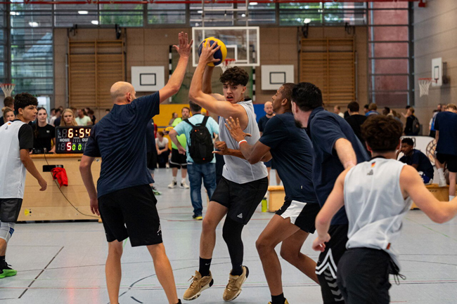 Schüler zwischen drei gegnerischen Spielern verteidigt Ball erfolgreich