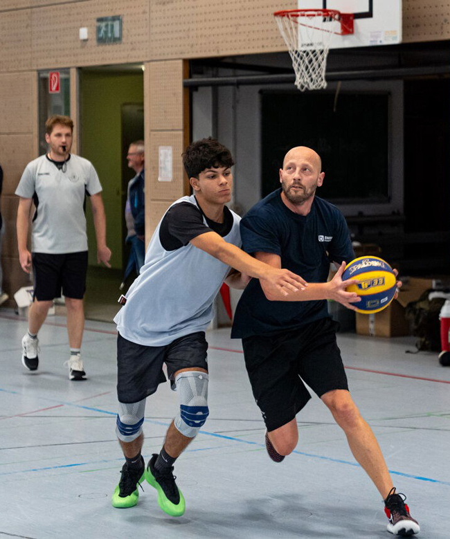 Schüler versucht gegnerischen Spieler mit Ball zu blocken