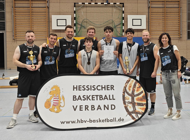 Lehrerteam und drei Schüler mit Schulleiterin im Wizards-Trickot vor einer Tafel mit der Aufschrift "Hessischer Basketball Verband"