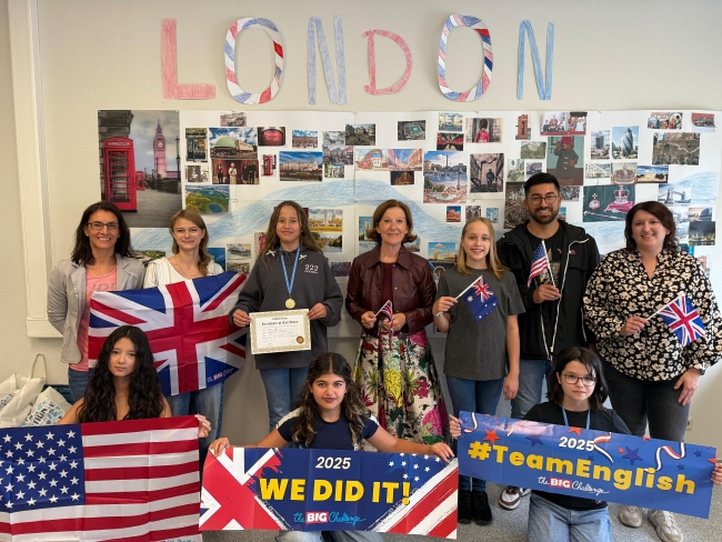 Gruppenbild mit Preisträgern, ihren Lehrern und englischen Flaggen sowie dem Schriftzug LONDON im Hintergrund