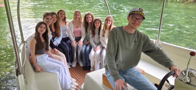 Chorschüler auf einem Boot auf einem Fluss